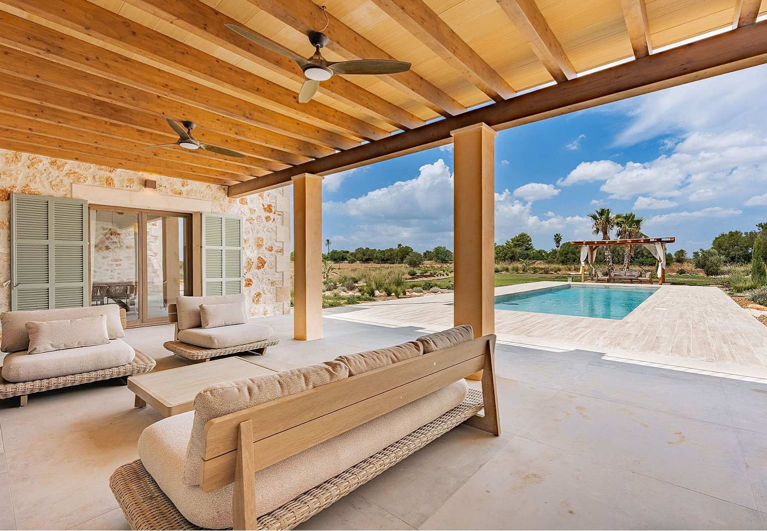 Überdachte Terrasse mit Pergola, Lounge und Blick auf den Pool auf Mallorca